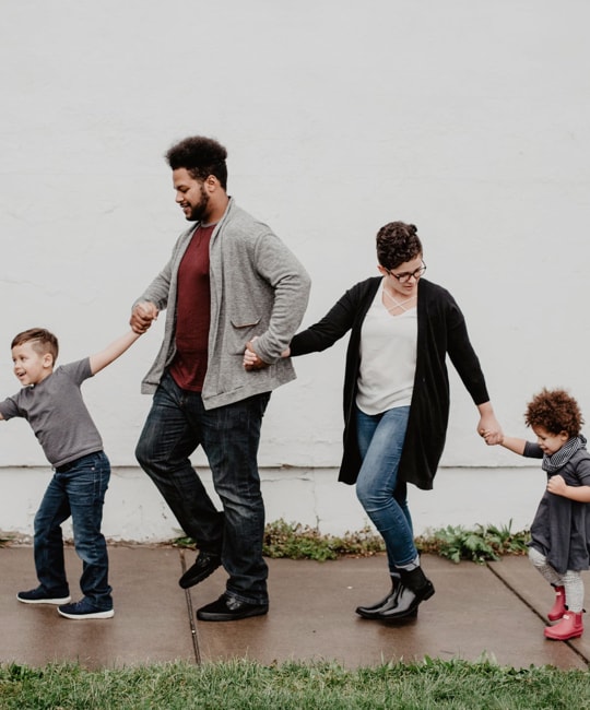 A family of four holding hands